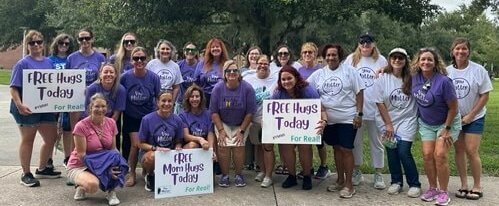 group of women holding Free Hugs Today signs