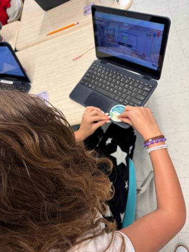 student putting sticker on laptop