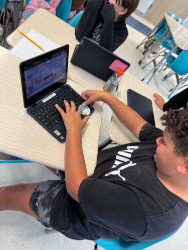 kid putting sticker on laptop